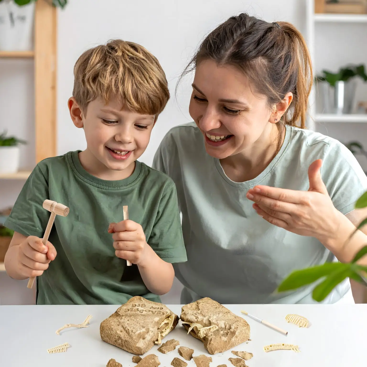 Child using the wooden hammer and chisel with adult supervision during the crocodile excavation activity